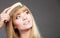 Closeup woman combing her fringe with comb