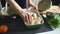 Closeup of woman cook hands put into pan chiken wings in kitchen at home