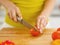 Closeup on woman cutting tomato on cutting board