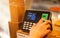 Closeup woman employee using biometric fingerprint machine for attendance system with numeric keypad at work