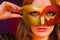 Closeup woman face with carnival golden red mask on dark