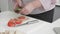 Closeup woman fat cutting tomato on chopping board with knife for preparation making to sandwich in the kitchen at home.