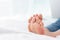 Closeup woman feet skin wearing jeans on white bed. Healthcare and health medical concept