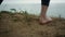 Closeup woman feet standing tophill. Unknown barefoot girl stop on dry grass.