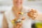 Closeup on woman giving spoon with fruits salad