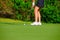 Closeup of woman golfer putting on the green