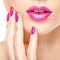 Closeup woman hand with pink nails near lips.