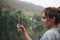 Closeup of a woman hand raising her smartphone up taking a photo of nature travel and tourism concept