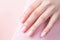 Closeup woman hand with soft pastel color nail polish on fingernails. Nail manicure with gel polish at luxury beauty salon. French