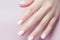 Closeup woman hand with soft pastel color nail polish on fingernails. Nail manicure with gel polish at luxury beauty salon. French