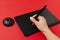 Closeup of woman hand, stylus and black graphics tablet on the red surface.Colorful creativity