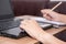 Closeup a woman hand using a laptop computer working at her desk in the office. A businesswoman is writing down her work in a