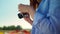 Closeup woman hands holding professional photo camera in blooming garden outdoor