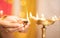 Closeup of woman hands lighting lantern diya or Lamp during festival ceremony - concept of traditional Indian festival