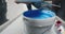 Closeup woman hands opening the bucket of blue paint preparing for home repairs