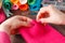 Closeup of woman hands sewing pink hamdmade toy