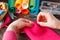 Closeup of woman hands sewing pink hamdmade toy