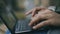 Closeup of woman hands typing at laptop outdoors