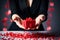 Closeup of woman holding gift box with red heart confetti around