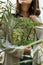 Closeup of woman holding mirror with sea buckthorns berries bushes reflection