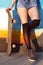 Closeup on woman legs next to skateboard
