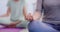 Closeup of a woman meditating with mudra hand gesture during a fitness class in a yoga studio. Calm, relaxed and focused