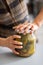 Closeup on woman opening jar of pickled cucumbers