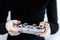 Closeup of woman with red nail polish holding a gaming controller with Super Nintendo retro design playing video games