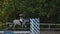 Closeup of a woman in riding gear sitting in a saddle on a chestnut horse horse while out for ride in the countryside.