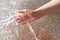 Closeup of woman`s hand cooling in a water fountain