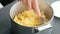 Closeup woman`s hand making mashed potato use fork in saucepan. Cooking mashed potatoes.