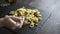 Closeup of a woman`s hand that pick up with a fork steaming orecchiette with broccoli, typical Apulian recipe, in backlight on dar