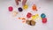 Closeup of a woman\'s hand picking up messy colorful macaron (macaroon) candy dessert and it\'s tiny bits which smash and squash on