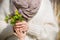 Closeup of woman`s hands holding a beautiful bunch of wild spring flowers and a child`s hand. Mother and son