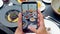 Closeup of a woman's hands using smartphone to take photos of dinner