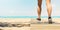 Closeup of woman`s legs walking on wooden path on beach