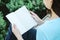 Closeup woman sitting for reading a book in free time in the garden in relax time of asian woman concept