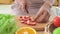 Closeup of woman slicing red strawberries with vegetable and fruits for making healthy salad. Food cooking and ingredients.