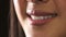 Closeup of a woman smiling with joy. Zoom in on mouth, lips and teeth of a cheerful, charming and confident female