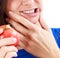 Closeup of woman in strong toothache pain with hands over face.