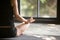 Closeup of woman in Sukhasana pose with mudra, rear view