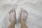Closeup of woman tanned barefoot standing on white sand beach. Travel concept. Happy feet in tropical paradise