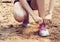 Closeup of woman tying shoe laces. Female sport fitness runner getting ready for jogging outdoors on forest path i