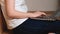 Closeup woman is typing on her laptop sitting on a floor. Home office concept during quarantine of coronavirus.