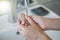 Closeup of a woman washing hands with soap lather over bathroom sink. Girl cleaning hand