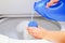 Closeup womans hands pouring detergent into to measure cup for washing machine, laundry housework concept