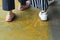 Closeup of women\'s feet in sneakers walking on textured metal pavement