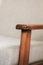 Closeup of the wooden arm of a white armchair
