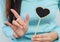 Closeup wooden black board in heart shape with finger of woman in love mean