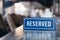 Closeup wooden blue white rectangular plate with the word Reserved standing on gray table in restaurant. Ð¡oncept of preparation